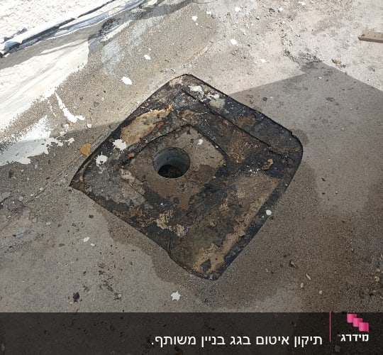 פתח ניקוז עם איטום ישן על גג בטון